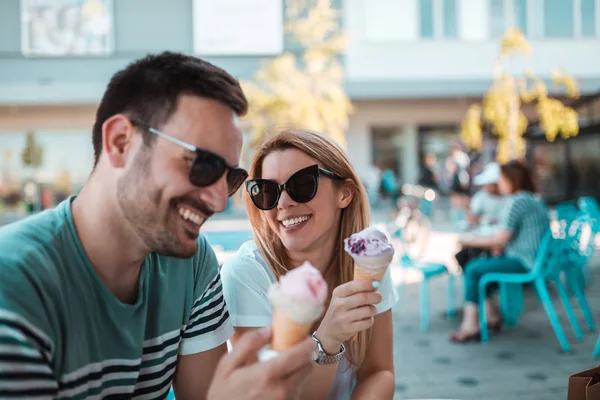 güzel genç çift güneş gözlüğü ile açık havada oturma ve dondurma sahip
