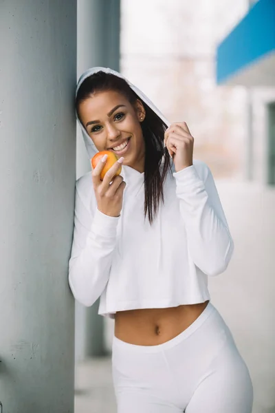 Young Fit Woman Sportswear Eating Apple While Standing Next Pillar — Stock Photo, Image