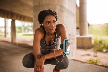 Genç Afro-Amerikan kadın sahip çalışan kırmak ise kulaklık müzik dinlerken spor giyim