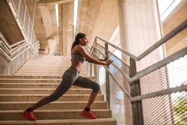 Sportif kadın merdivenlerde germe egzersizleri yapıyor bitmiş kardiyo egzersizi sonra spor giyim