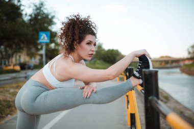 Genç bayan esniyor ve koşmaya hazırlanıyor.