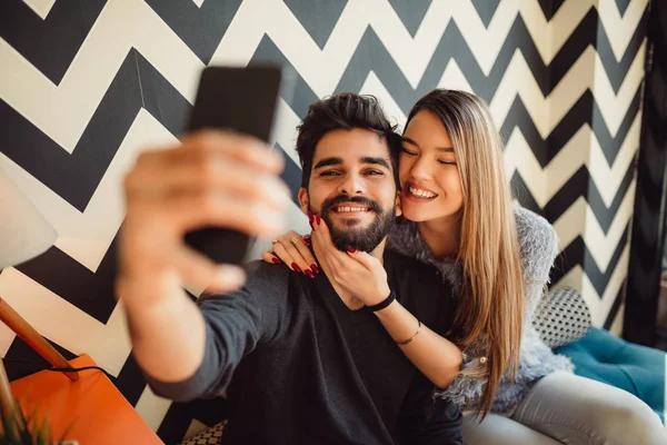 美しい若いカップルは Selfie スマート フォンを使って カフェに座ってながら笑顔を作ってください — ストック写真