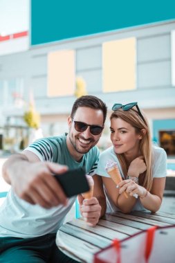 Dondurma ve güneşli gün zevk alarak selfie sahip mutlu genç çift.
