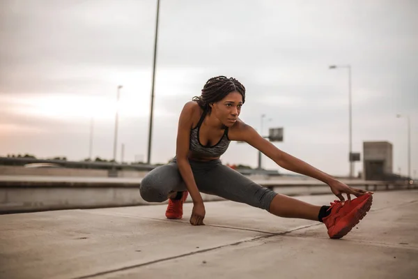 年轻的非洲裔美国妇女做热身和伸展她的腿前晨跑 — 图库照片