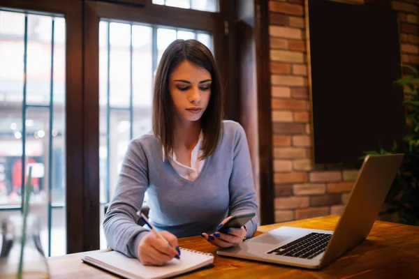 Young Attractive Brunette Writing Notes She Just Received Her Mobile — Stock Photo, Image