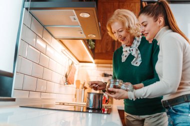 Anne ve kızı birlikte vakit geçirmekten zevk alıyorlar. Mutfakta kahve yapıyorlar.. 