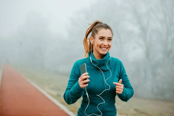 Young Fit Girl Listening Music Her Smartphone While Running Foggy — Stock Photo, Image