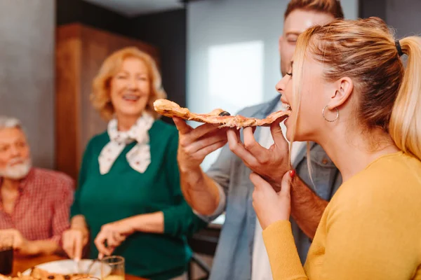 Young Man Feeding His Girlfriend Slice Pizza His Parents Eating — Stock Photo, Image