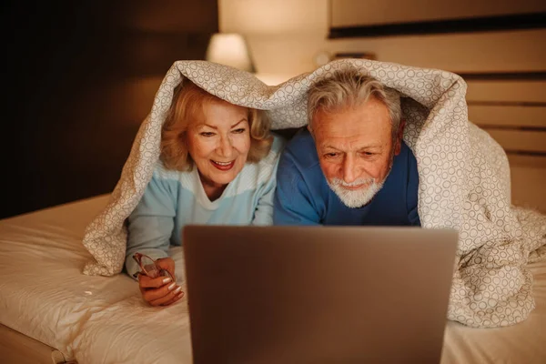 Charmant Couple Personnes Âgées Utilisant Ordinateur Portable Tout Étant Couché Photos De Stock Libres De Droits