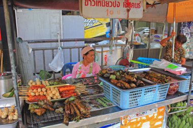 Tay gıda durak, hafta sonu market, Phuket town, Tayland kadın fastfood satıcısını geleneksel Tay yemekleri, tavuk ve domuz eti spesiyalleri müşterilere satış. 
