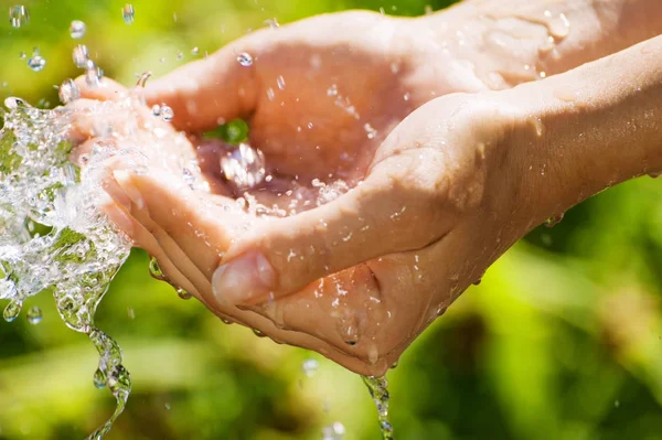 Woman washing hand outdoors. Natural drinking water in the palm. Young hands with water splash, selective focus — Stock Photo, Image