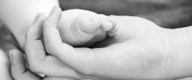 Bebe ayak anne elinde Panoraması. kavramı mutlu aile ve aile desteği, siyah beyaz fotoğraf