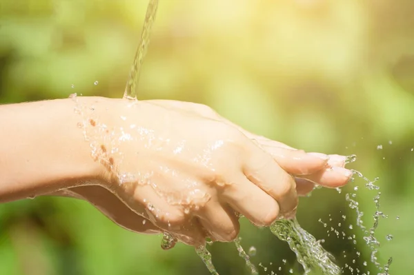 Woman washing hand outdoors. Hands with water splash, selective focus — Stock Photo, Image