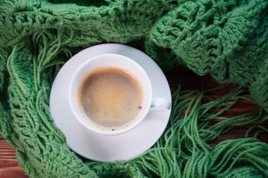 Üstten Görünüm bir fincan sıcak kahve ve sıcak yeşil eşarp. Coziness ve sıcaklık kavramı