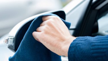  Yetişkin insan eli mavi mikrofiber bezle Panoraması ayna temizliyor. Temiz araba konsepti. Erkek handfrom pencere yan görünüm