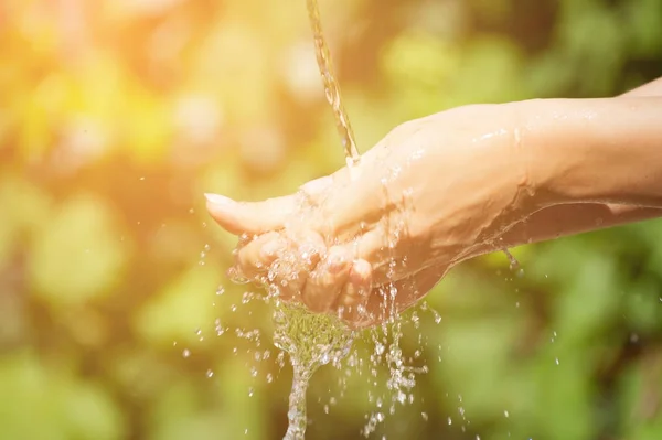 Woman washing hand outdoors. Natural drinking water in the palm. — Stock Photo, Image