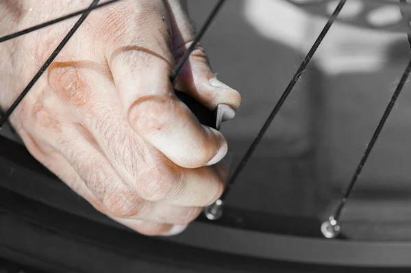 El hombre está abriendo el pezón y preparándose para bombear neumáticos de bicicleta al aire libre, primer plano de las manos — Foto de Stock