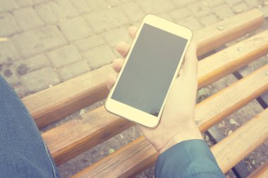 İnsan eli dikey görünüm akıllı telefon kullanıyor. Kış zamanı. Kavram bekleyen veya toplantı. Outdoor.Instagram