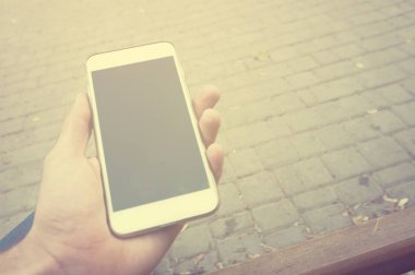 İnsan eli dikey görünüm akıllı telefon kullanıyor. Kış zamanı. Kavram bekleyen veya toplantı. Outdoor.Instagram