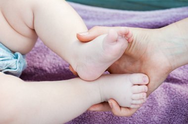 Bebe ayak anne elinde. Küçük yeni doğan bebek ayaklar, mutlu aile kavramı. Phot sahte renk tonu