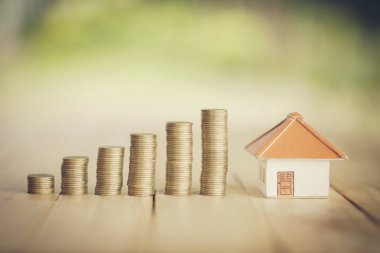 Madeni paraların üzerine yerleştirilen ev, emlak merdiveni, ipotek ve emlak yatırımları için konsept konsepti satın almak amacıyla madeni paradan tasarruf etmeyi planlıyor. bir ev için para biriktirmek ya da yatırım yapmak,