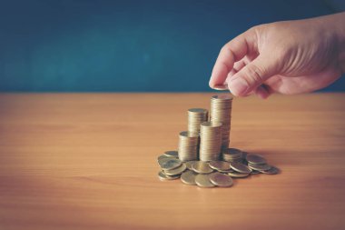 para tasarrufu ve iş kavramı büyüyen para sikke yığını koyarak el kadar kapatın