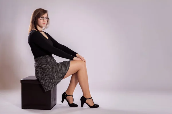 Una giovane ragazza è seduta su uno sgabello — Foto Stock