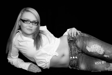 Genç kadın mavi kot pantolon ve beyaz bir üst katta yatıyor