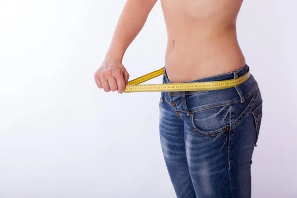 Mulher em jeans com uma fita métrica — Fotografia de Stock