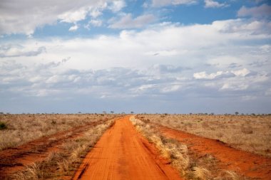 Kırmızı toprak yol, mavi gökyüzü bulutlu, Kenya toplayan
