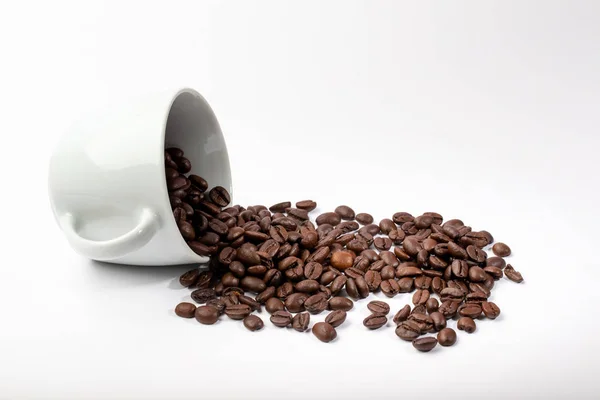 White cup with coffee beans on white background — 스톡 사진