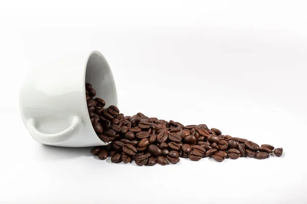 Tasse blanche avec grains de café sur fond blanc — Photo