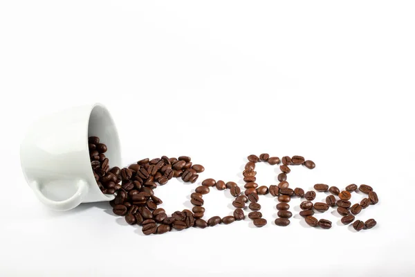 White cup with coffee beans on white background — 스톡 사진