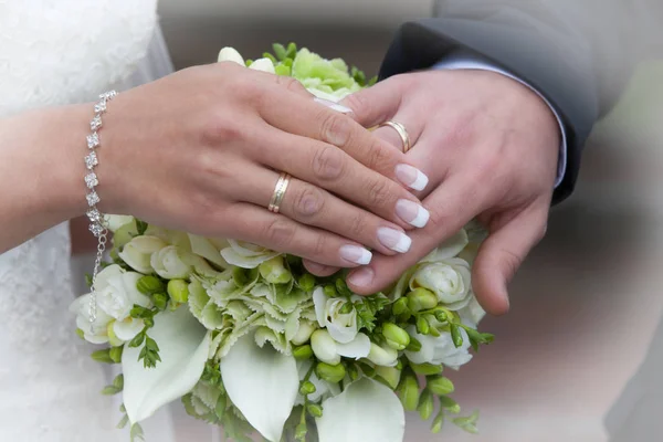 新婚夫妇的手拿着结婚戒指 — 图库照片