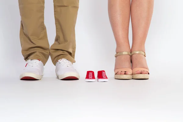 Twee paar meter van de ouders en schoenen van een ongeboren baby. — Stockfoto
