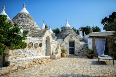 Ceglie Messapica, İtalya. Tipik trulli binalar arasında yeşil bitkiler ve çiçekler, ana turistik bölge, konik çatı Val d' Itria, Apulia Bölgesi, Güney İtalya,