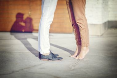 Bacaklar gölgeler ile öpüşen çiftin yakın çekim