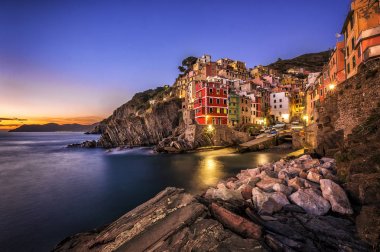 Riomaggiore balıkçı köyü gün batımında. Riomaggiore beş ünlü renkli köyleri, Cinque Terre'nin İtalya, deniz ve kara üzerinde dik kayalıklarla arasında askıya biridir. Liguria, İtalya