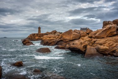 Ploumanac 'h Mean Ruz deniz feneri Pembe granit sahilindeki kayaların arasında, Perros Guirec, Brittany, Fransa.