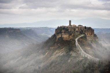 Civita di Bagnoregio, Viterbo, Lazio, İtalya: Antik köyün dik tüf tepede sisin içinde kefen şafakta güzel manzara