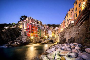 Riomaggiore balıkçı köyü gün batımında. Riomaggiore İtalya, deniz ve kara üzerinde dik kayalıklarla arasında askıya beş ünlü renkli köyleri, Cinque Terre'nin (beş topraklar) biridir. Liguria, İtalya