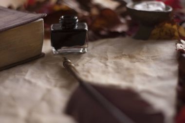 Tüy kalem ve mürekkep, mum ve İncil'in üzerine wo ile boş eski kağıt