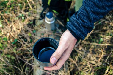 Termos kupa çay onun el, haking Duraklat, yakın çekim ile tutan adam