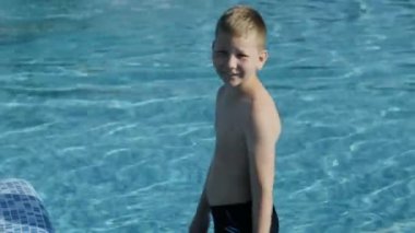 Küçük çocuk siyah Yüzme şort mavi havuza atlar