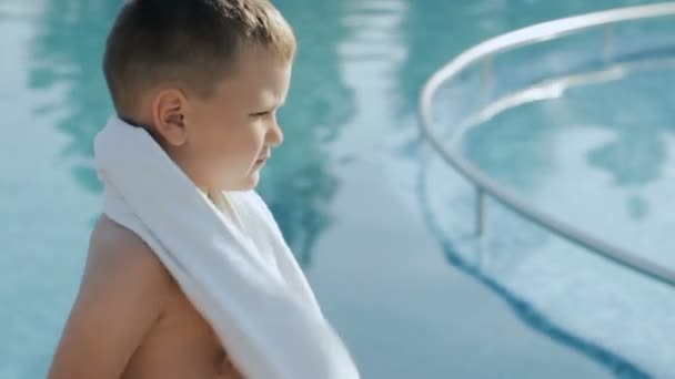 Baby med vit handduk nära poolen ler — Stockvideo