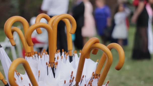 Witte paraplu's-sticks zijn klaar. Mensen op de achtergrond zijn onherkenbaar — Stockvideo