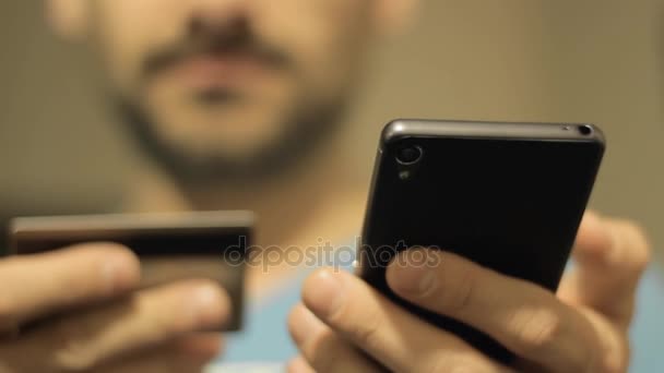 La persona muestra un teléfono y una tarjeta de crédito — Vídeo de stock