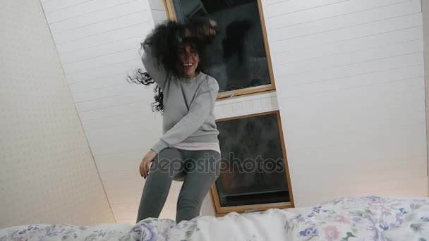 Mulher saltando e caindo em câmera lenta em sua cama — Vídeo de Stock