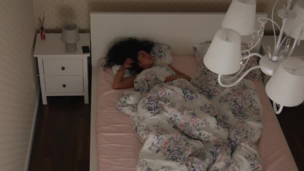 Chica inquieta duerme en la cama por la noche Top view — Vídeos de Stock