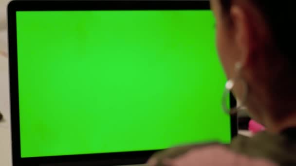 Chica en ropa de camuflaje hace videollamada en el ordenador portátil con pantalla verde — Vídeos de Stock